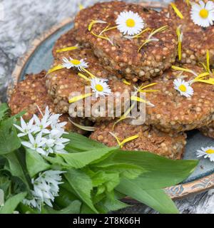 selbstgemachte Kräuterpasteten mit wildem Knoblauch auf einem Teller, dekoriert mit Gänseblümchen Stockfoto