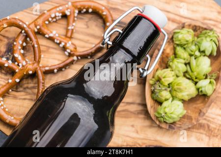 Gewöhnlicher Hopfen (Humulus lupulus), Flaschenbier und Hopfenkegel und herzhafte Snacks Stockfoto