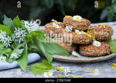 selbstgemachte Kräuterpasteten mit wildem Knoblauch auf einem Teller, dekoriert mit Gänseblümchen Stockfoto