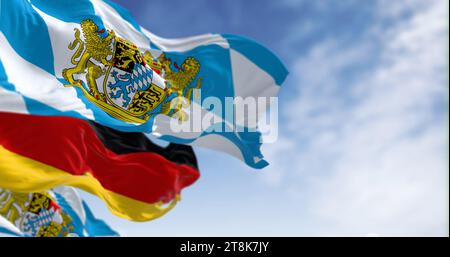 Bayerische Fahnen, die an einem klaren Tag mit deutscher Nationalflagge wehen. Bayern ist ein Bundesstaat im Südosten Deutschlands. 3D-Darstellung. Selektiver lichtwellenleiter Stockfoto