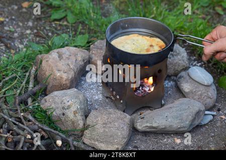 Bannockherstellung, wird auf offenem Feuer gebacken, Brotteig wird gebildet und in einer Pfanne auf einem Campingkocher gebacken, Serienbild 5/5 Stockfoto