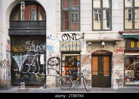 KOPENHAGEN, DÄNEMARK - 17. Juni 2006. Urbane Grunge-Straßenszene, Fahrrad parkt vor einem Laden mit Graffitis in Kopenhagen, Dänemark. Stockfoto