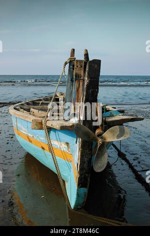 Ein Fischerboot lehnt sich an das Ufer Stockfoto