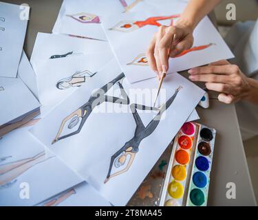 Eine gesichtslose Frau zeichnet Aquarelle von Sportbekleidung. Nahaufnahme der Hände eines Modedesigners. Stockfoto