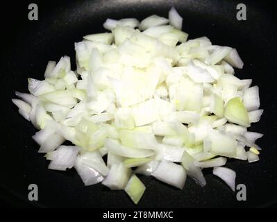 Gehackte Zwiebeln in einer Pfanne anbraten Stockfoto