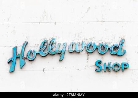 Galveston, USA - 10. November 2023: Verrottete und schmutzige Neonwerbung für Hollywood-Shop in einem alten Backsteinhaus aus dem 19. Jahrhundert in Galveston, Stockfoto