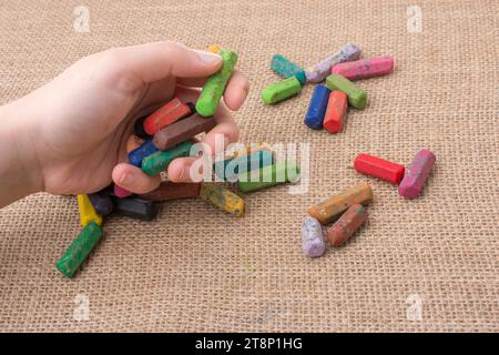 Benutzte Farbstifte und eine Hand, die etwas hielt Stockfoto