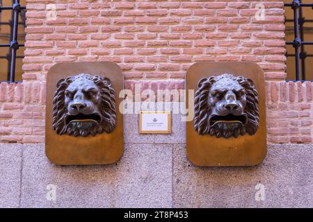 Toledo, Spanien, 08.10.21. Zwei bronzene Löwenkopf-Skulpturen-Postkästen an einer Backsteinfassade in Toledo, Spanien. Stockfoto