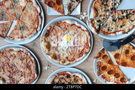 Von oben nach unten eine Vielzahl von Pizzen und Chips, die in einem kreisförmigen Muster auf weißem Hintergrund angeordnet sind Stockfoto