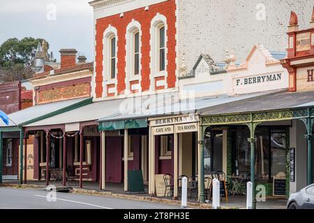 Schmiedeeiserne und kunstvoll verzierte Verandapfosten vor alten Gebäudefassaden in einer historischen Straßenlandschaft in Maldon in Central Victoria, Australien Stockfoto