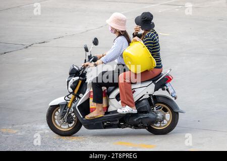 Zwei Frauen tragen Fracht auf einem Motorrad, Thailand Stockfoto