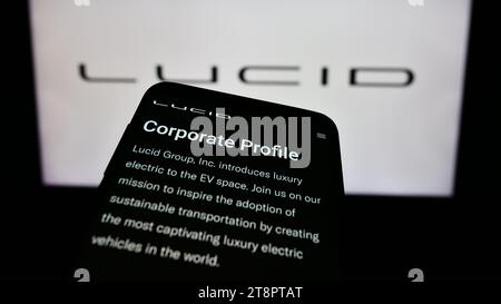 Mobiltelefon mit Website des US-amerikanischen Unternehmens für Elektrofahrzeuge Lucid Motors vor dem Geschäftslogo. Fokussieren Sie sich oben links auf der Telefonanzeige. Stockfoto