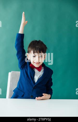 Ein Junge in einer Lektion hebt seine Handschulklasse auf Stockfoto