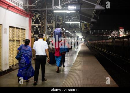 Dhanbad, Jharkhand, Indien - 26. Oktober 2023: Porter oder Coolie mit Gepäck einer Familie auf einem indischen Bahnsteig bei Nacht Stockfoto