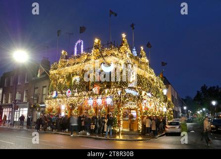 Die Churchill Arms mit über 22.000 Lichtern, die das Äußere des West London Pubs beleuchten, erhellt den Nachthimmel mit ihrer Weihnachtsbeleuchtung am 18. November 2023 in London, Großbritannien. Stockfoto