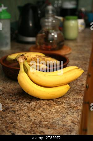 Bananen liegen auf einem soliden Holztisch. Süße reife Bananen mit gelber Haut Stockfoto