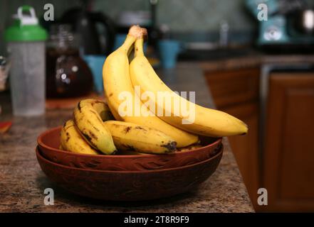 Bananen liegen auf einem soliden Holztisch. Süße reife Bananen mit gelber Haut Stockfoto