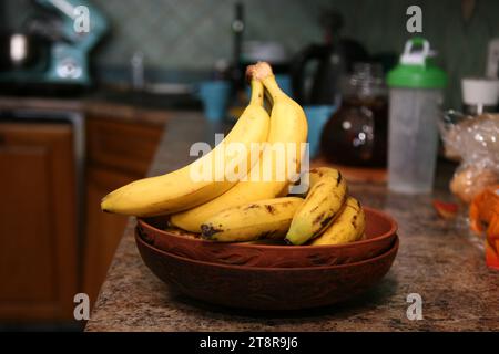 Bananen liegen auf einem soliden Holztisch. Süße reife Bananen mit gelber Haut Stockfoto