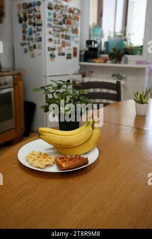 Bananen liegen auf einem soliden Holztisch. Süße reife Bananen mit gelber Haut Stockfoto