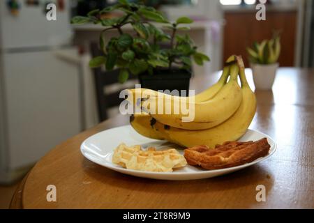 Bananen liegen auf einem soliden Holztisch. Süße reife Bananen mit gelber Haut Stockfoto