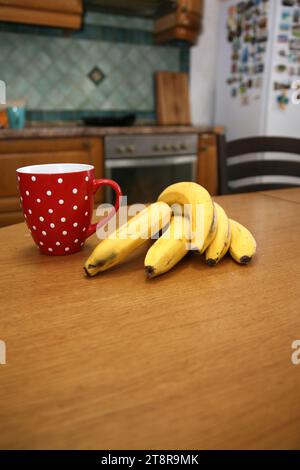 Bananen liegen auf einem soliden Holztisch. Süße reife Bananen mit gelber Haut Stockfoto