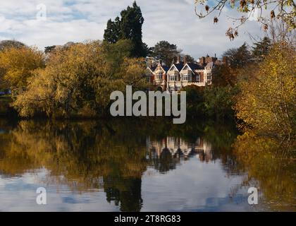 Bletchley Park Mansion, berühmt für die Heimat der Code-Breakers und das Brechen des Geheimniscodes während des 2. Weltkriegs, spiegelt sich im Herbst in einem nahe gelegenen See wider. Stockfoto