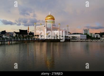 Sultan Omar Ali Saifuddin Moschee. Brunei, 1958 fertiggestellt, ist Masjid Omar Ali Saifuddien – benannt nach dem 28. Sultan von Brunei (dem verstorbenen Vater des heutigen Sultans) – von einer künstlichen Lagune umgeben, die als reflektierendes Becken dient. Da Brunei ist, ist das Innere ziemlich üppig. Der Boden und die Wände sind aus feinstem italienischem Marmor gefertigt, die Kronleuchter wurden in England gefertigt und die luxuriösen Teppiche wurden aus Saudi Arabien eingeflogen. Ein 3,5 Millionen Stück großes Glasmosaik mit echtem Blattgold bedeckt die Hauptkuppel Stockfoto