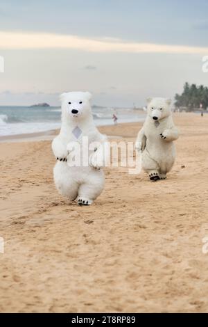 Animateure, die als Eisbären verkleidet sind, unterhalten die Leute am Strand Stockfoto