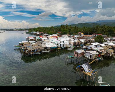 Boote neben Stelzenhäusern in Zamboanga, die auf Stelzen gewachsen sind. Klares Meerwasser mit türkisfarbenem Wasser. Mindanao, Philippinen. Stockfoto