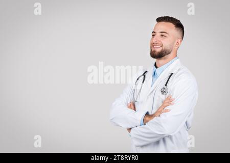 Lächelnder europäischer Arzt mit überkreuzten Armen. Stockfoto
