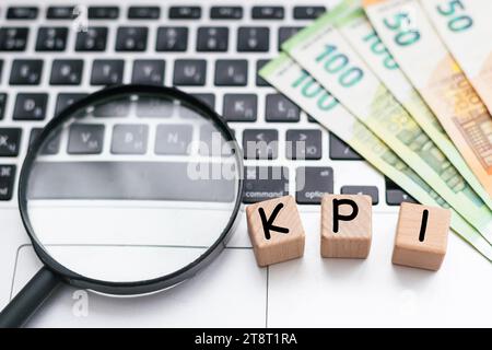 KPI auf Holzwürfel auf Tastatur mit Bürowerkzeugen geschrieben Stockfoto