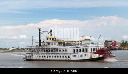 Das Schaufelradschiff Creole Queen ist ein 1.000-Personen-Flussboot, das vom Hafen von New Orleans aus verkehrt. Sie wird von New Orleans Paddlewheels, Inc. Betrieben Sie wurde von Halter Marine in Moss Point, Mississippi, nach dem Vorbild eines Windräders aus der Jahrhundertwende gebaut und im September 1983 in Dienst gestellt. Sie ist 190 Fuß (57 Meter) lang und 40 Fuß (12 Meter) breit. Sie verfügt über drei Decks, von denen zwei drei Speise- und Banketträume und ein drittes Oberdeck für überdachte Sitzgelegenheiten im Freien beherbergen. Ihre Bruttoraumzahl beträgt 397. Stockfoto