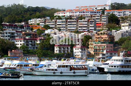 Sai Kung. Hongkong, die Halbinsel Sai Kung, ist bekannt für ihre malerischen Fischerdörfer und Wanderwege. Eines der beliebtesten Reiseziele ist die Stadt Sai Kung, wo ein geschäftiger schwimmender Fischmarkt die Restaurants im Freien am Wasser beliefert. An anderer Stelle führen Wanderwege durch zwei Country Parks und genießen einen atemberaubenden Ausblick und vulkanische Felssäulen im High Island Reservoir. Tai Long Wan Bay hat ruhige Sandstrände, die bei Surfern beliebt sind Stockfoto