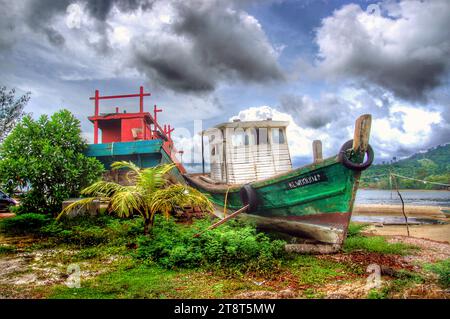 Das alte Boot Langkawi, Langkawi, offiziell bekannt als Langkawi, das Juwel von Kedah, ist ein Distrikt und ein Archipel von 99 Inseln in der Malakka-Straße. Etwa 30 km vor der Küste des Nordwestens Malaysias. Die Inseln sind Teil des Bundesstaates Kedah, der an die thailändische Grenze grenzt Stockfoto