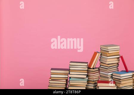 Pädagogische Wissenschaftsstapel in der Bibliothek auf rosa Hintergrund Stockfoto