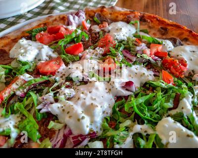 Pizza mit Fleischtomaten, Zwiebeln und Joghurt, Nahaufnahme, selektiver Fokus. Stockfoto