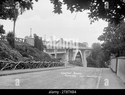 Blick auf Grafton Bridge, Auckland, Neuseeland, von Bridge Street, Grafton, Blick auf die Grafton Bridge von der Bridge Street aus mit Blick auf die Brücke in Richtung Symonds Street End Ein Pferd steht unter der Brücke. Ein rustikaler Zaun grenzt an den Garten am Ufer des Ufers an die Brücke. Grabsteine auf dem Symonds Street Cemetery, wie auf der rechten Seite des Fotos zu sehen. Aufgenommen von Auckland, Neuseeland am 1. Oktober 1913 Stockfoto