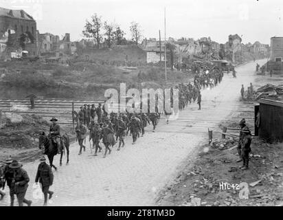 Ein neuseeländisches Bataillon, das durch das zurückeroberte Bapaume fährt, im Ersten Weltkrieg, Ein Blick über das zurückeroberte Bapaume, Frankreich, und zeigt eine Kolonne von Truppen eines neuseeländischen Bataillons, die sich auf die Kamera zubewegen. Zwei Krankenwagen sind im Hintergrund zu sehen. Ebenfalls sichtbar sind die Schäden an der Stadt selbst. Foto vom 14. September 1918 Stockfoto