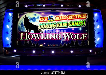 Detailaufnahme einer beleuchteten Titelzeile der Slots Heulling Wolf auf einem der beliebten Spielautomaten in einem Casino-Bereich an Bord. Stockfoto