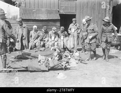 Verletzte deutsche Gefangene aus dem Ersten Weltkrieg in Louvencourt, Frankreich, verletzte deutsche Kriegsgefangene in einer New Zealand Casualty Clearing Station in Louvencourt während des Ersten Weltkriegs Einige liegen auf Bahren auf dem Boden. Andere, ihre Wunden verbunden, sitzen oder stehen und warten auf den Krankenwagen. Die neuen Zealander beaufsichtigen sie. Foto vom 22. April 1918 Stockfoto