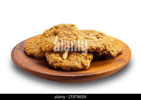 Köstliche hausgemachte knusprige Kokosplätzchen in Holzplatte isoliert auf weißem Hintergrund mit Schneidepfad. Stockfoto