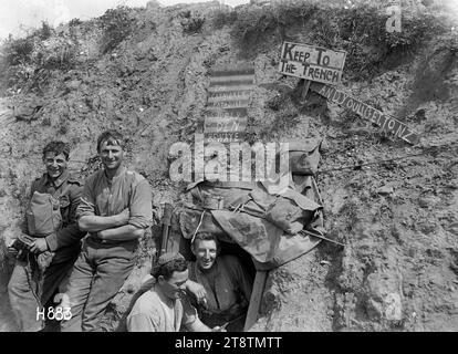 Neuseeländische Soldaten mit dem "Kannibals Paradies"-Schild im Ersten Weltkrieg, Frankreich, vier neuseeländische Soldaten aus dem Ersten Weltkrieg posieren in einem Frontgraben unter dem auf Wellblech gemalten Schild „The Cannibals Paradise Supply den Beware“ als Reaktion auf die deutsche Propaganda, dass Neuseeländer ihre Gefangenen aufgefressen hätten. (Soldat 2. Von links könnte Ted Brosnahan sein) ebenfalls auf der Grabenwand befindet sich ein offizielles hölzernes Schild „Keep to the Graben“. Darunter befindet sich ein weiteres hölzernes Schild mit der in Großbuchstaben gemalten Aufschrift „and youl sic get to NZ“. Foto von Gommecourt Wood am 10. August 1918 Stockfoto