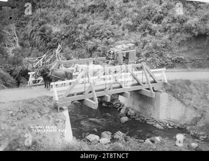 Ngutunui Bridge, Te Rauamoa, Foto, das eine Pferdekutsche über die Ngutunui (damals Nutanui) Brücke in Te Rauamoa, Otorohanga zeigt. Zeigt eine Fachwerkbrücke über einen Fluss im Busch; und eine Kutsche mit drei Passagieren und ihrem Gepäck hielt oben an. Aufgenommen um 1900-1910 Stockfoto