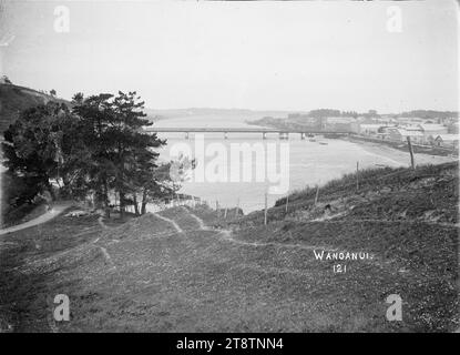 Blick auf Wanganui, Neuseeland Blick auf den Wanganui, New Zealand River in Richtung Victoria Avenue Bridge, Blick auf Wanganui, Neuseeland auf der rechten Seite des Whanganui River, Blick den Fluss hinunter in Richtung der Brücke, die zur Victoria Avenue führt. Foto von einem grasbewachsenen Hügel über dem Fluss Stockfoto