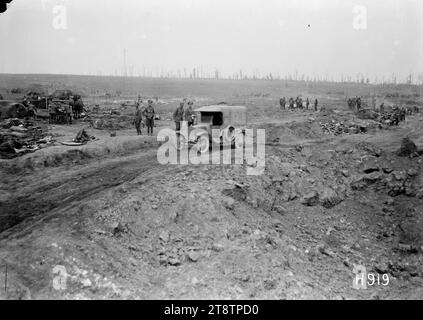 Ein Motorwagen, der ein riesiges Muschelloch in erbeutetem Boden passiert, Grevillers, 1. Weltkrieg, Ein Motorwagen, der auf einer unebenen Feldstraße fährt, passiert ein riesiges Muschelloch in erbeutetem Boden während des Ersten Weltkriegs Kleine Gruppen von Soldaten sind im Hintergrund sichtbar. Baumstümpfe erscheinen am Horizont. Foto in der Nähe von Grevillers, Frankreich, am 24. August 1918 Stockfoto