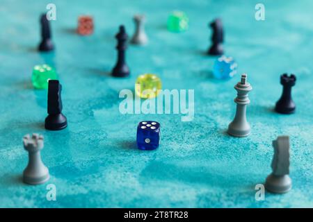 Schachfiguren und bunte Würfel auf blauem Aquarellhintergrund Stockfoto