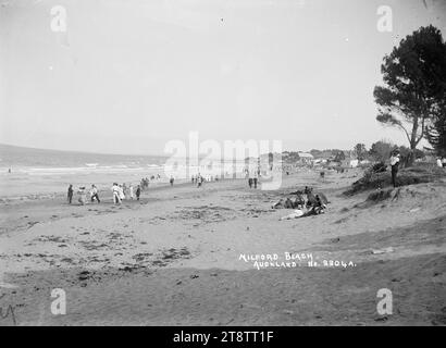 Milford Beach, Auckland, Neuseeland, Blick nach Südosten und zeigt Menschen am Milford Beach und im Meer. Anfang der 1900er Jahre Stockfoto