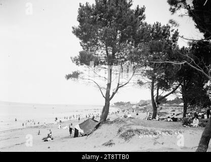 Milford Beach, Auckland, Neuseeland, Blick auf Milford Beach aus einer Gegend in der Nähe von Bäumen hinter dem Strand mit Blick nach Südosten. Man kann am Strand schwimmen und spazieren sehen. CA 1914 Stockfoto