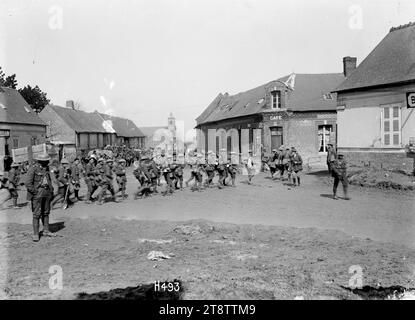 Neuseeländische Soldaten auf dem Weg zu den Schützengräben der Somme, Eine allgemeine Ansicht der neuseeländischen Truppen, die durch das französische Dorf Bertrancourt auf dem Weg zu den Schützengräben an der Somme fuhren. Sie nähern sich einem Café. Im Hintergrund steht eine Kirche. Foto vom 1. April 1918 Stockfoto