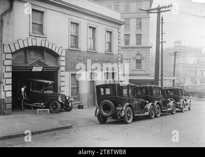 Checker Taxicab Company Ltd, Wellesley Street East, Auckland, Neuseeland, Blick auf das Gelände der Checker Taxicab Company Ltd an der Ecke Wellesley Street East und Lorne Street. Drei Fahrerhäuser stehen am Bordstein und eine vierte im Eingang der Garage, wo sie mit einer tragbaren Elektrolux-Reinigungsausrüstung gesaugt wird. Das Fullers' Opera House befindet sich auf der anderen Straßenseite in der Wellesley Street West. CA 1925-1930 Stockfoto